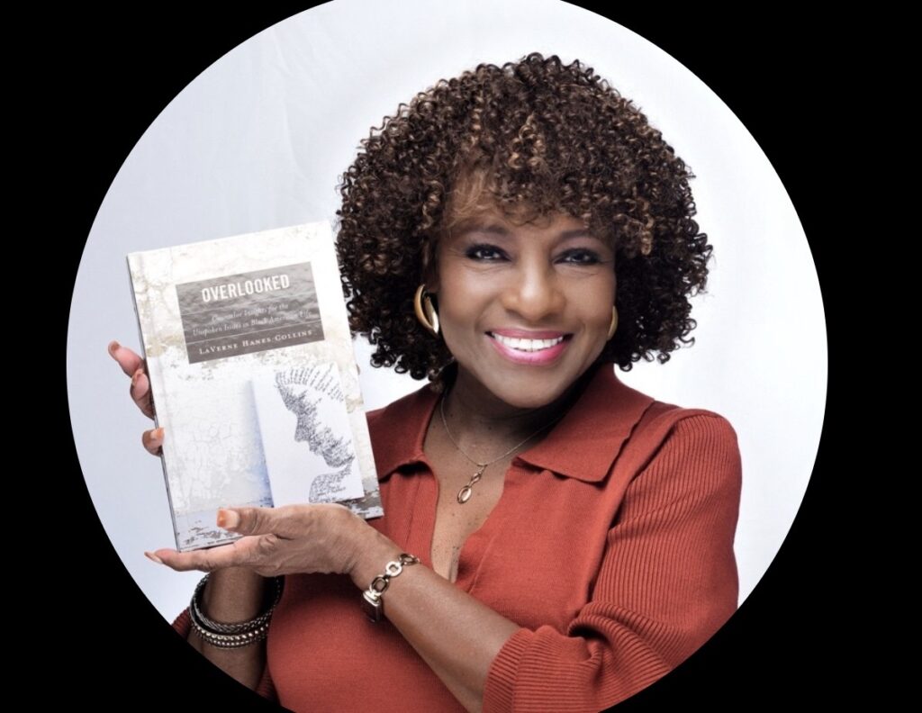 Dr. Laverne Haynes Collins smiling and holding her book entitled:  Overlooked.